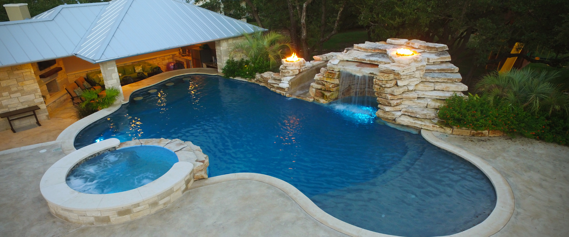 Custom backyard pool with a rock waterfall, fire features, and spa kept in perfect condition with professional pool repair in Leander